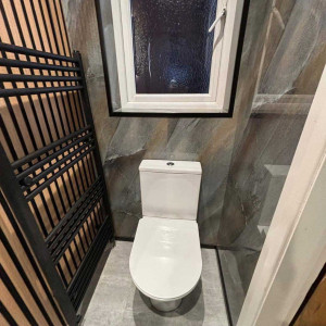 black radiator next to toilet wood acoustic