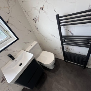 black radiator next to toilet and sink